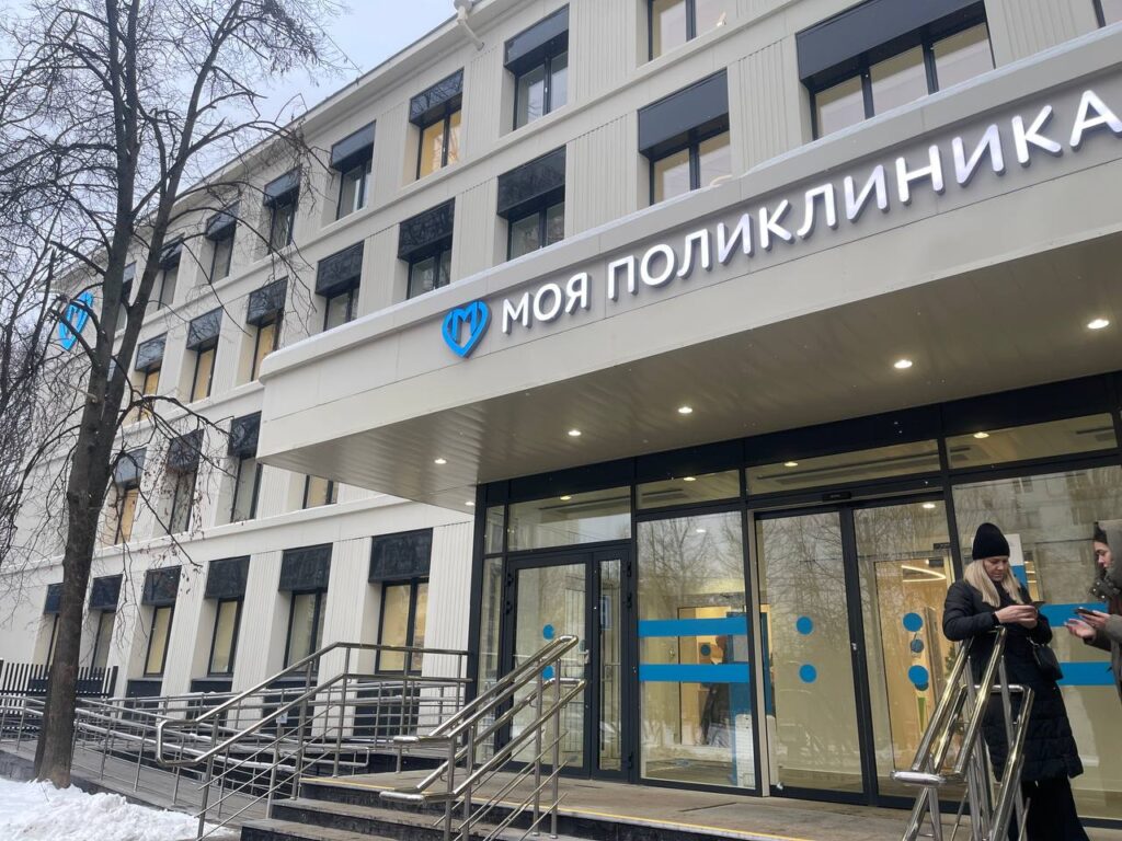 Фотография фасада поликлиники. Современное здание медицинского учреждения в городской среде.